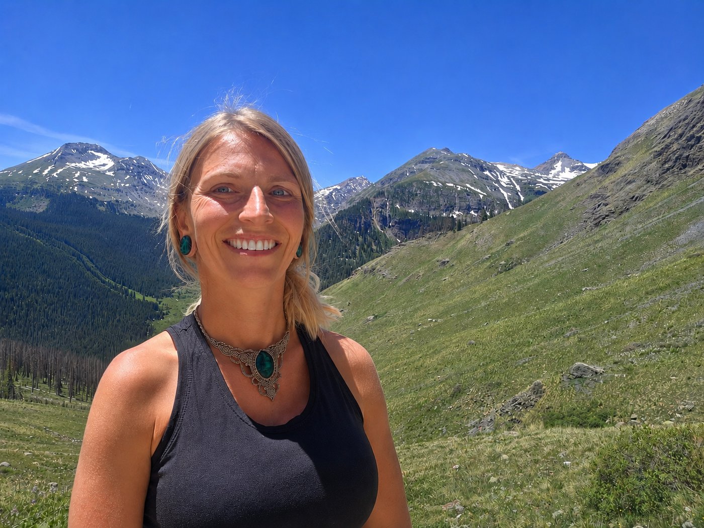 Suzie of Teal Ventures Realty in a green mountain valley